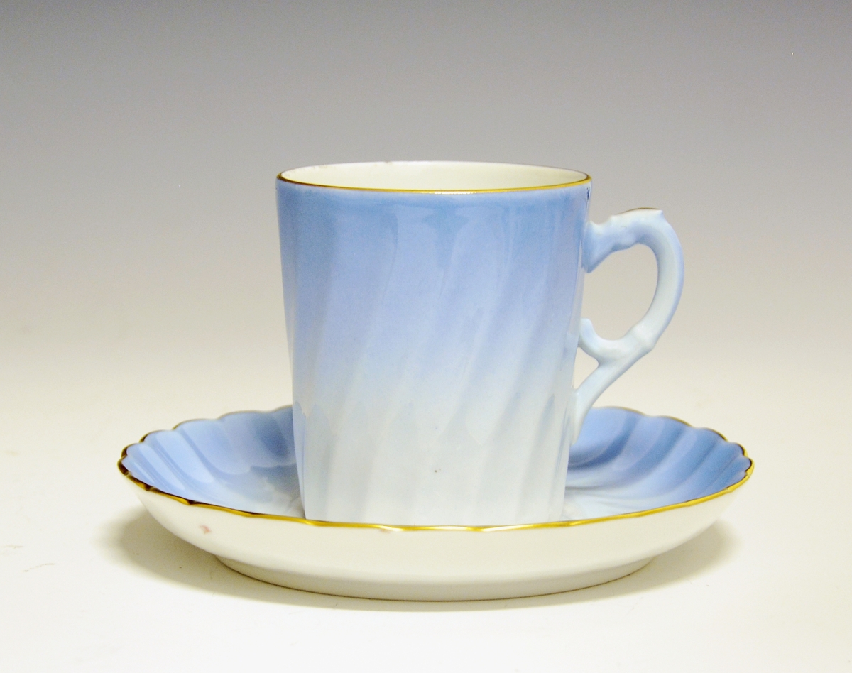 Kaffeskål i porselen. Dekorert i lyseblått og med gullkant.
Dekor Maud, i produksjon fra 1978-2006.
Modell Bogstad.
