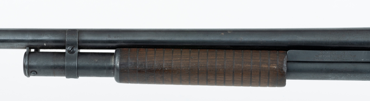 Winchester Model 1897, ei pumpehagle med rørmagasin, produsert av Winchester Repeating Arms Company i New Haven i Connecticut i USA (1866-2006). Dette våpenet er også kjent som Model 97, M97, eller Trench Gun. Model 1897 var en videreutvikling av Winchester Model 1893. Formgiveren bak disse våpnene var børsemakeren John Moses Browning (1855-1926). Model 97 regnes for å ha vært det første vellykte forsøket på å produsere ei pumpehagle. Magasinet sitter på undersida av løpets bakre del. Det er omgitt av et sylindrisk treskjefte. Når dette handtaket trekkes tilbake, trekkes også sluttstykkebolten bakover, slik at den tomme patronen kastes ut. Når det nevnte handtaket skyves framover igjen mates en ny patron inn i kammeret. Magasinene i Model 97 hadde vanligvis rom for 6 haglpatroner. Våpenet har full trangboring, det vil si at løpet, som bakfra har en diameter på 18,4 millimeter, men er cirka 1 millimeter trangere i den fremre enden. Dette ble gjort for å begrense spredningem haglene fikk på sin veg mot målet. Winchester Model 97 ble produsert i over én million eksemplarer i perioden 1897 til 1957. Ei innstemplet liste over patenter som ligger bak dette våpenet tyder på at den avbildete modellen er produsert etter 1906. Model 97 regnes som den første vellykte pumpehaglemodellen som kom på markedet. Den ble brukt av amerikanske soldater og politiavdelinger, samt av jegere. Her til lands har slike geværer vært omtalt som «Western-våpen». Den avbildete hagla er velbrukt, antakelig av en norsk jeger. Kolben, som ser ut til å være lagd av nøttetre, har tre innskårne bokstaver - «LBR» - som kan ha vært initialene til tidligere eier. 

Denne Winchester-hagla har vært innlånt til museet, men ble fotografert før den ble returnert til eieren.