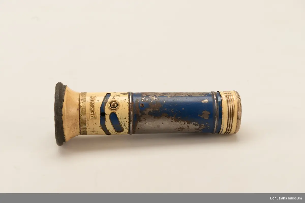 Cylinderformad ficklampa av blå och gulmålad plast. Av märke "Pertrix".