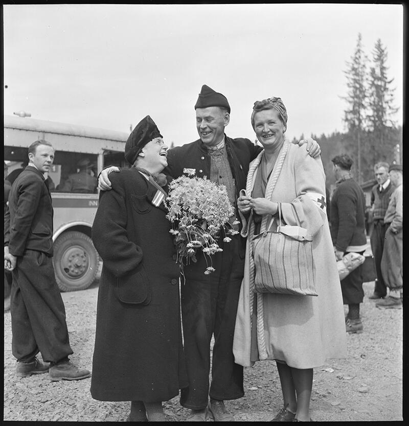 Two women and one man with their arms around each other. Liberation day at Grini prisoncamp, Norway in 1945.