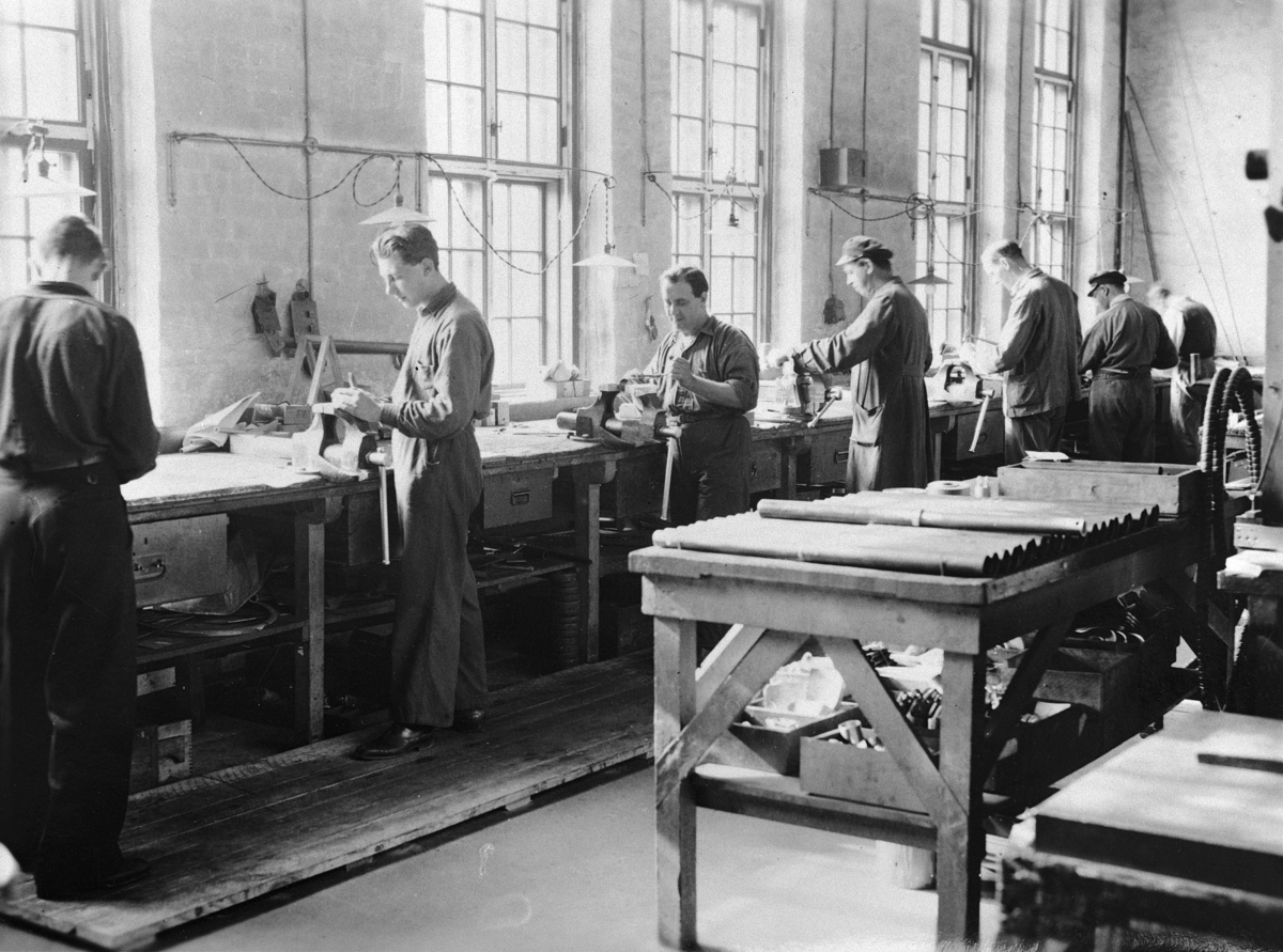 Interiör av filarverkstaden på Flygkompaniets verkstäder omkring 1920-1925. Sju män i arbete.