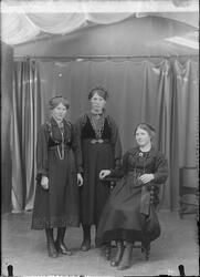 Gruppeportrett. Tre kvinner kledd i stakk og liv fotografert