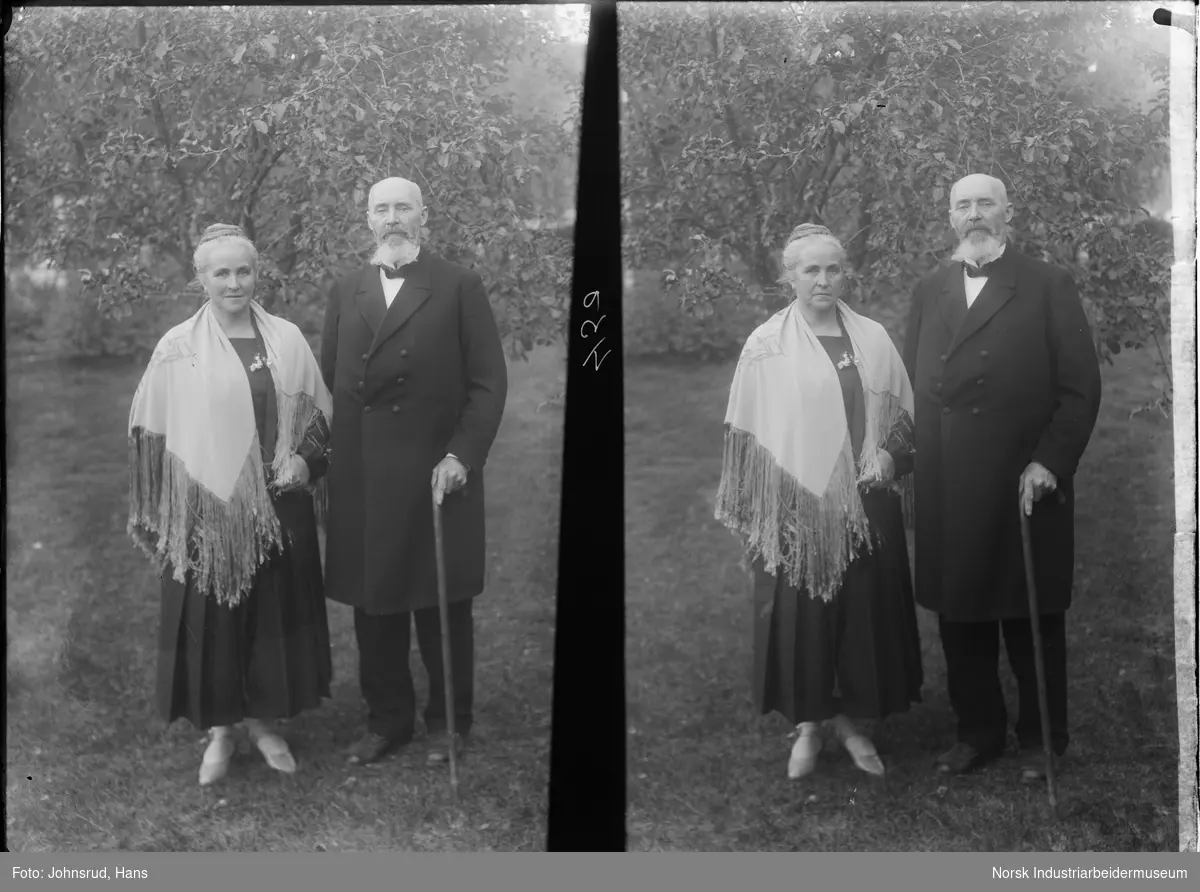 Dobbelportrett av Sogneprest Tisthal med kone. Mannen står med dobbeltspent frakk og stokk, kvinnen i kjole med sjal over skuldrene.