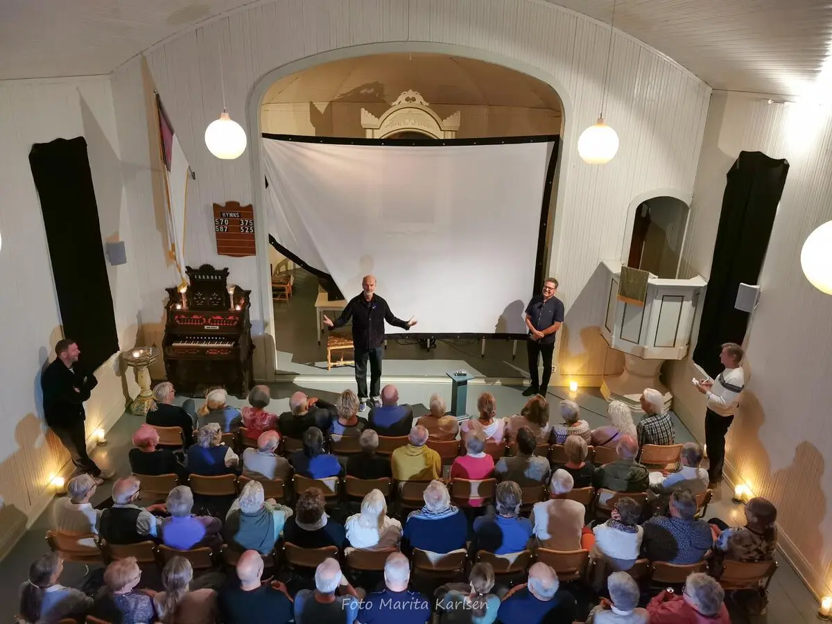 Erik Poppe står foran publikum og snakker.