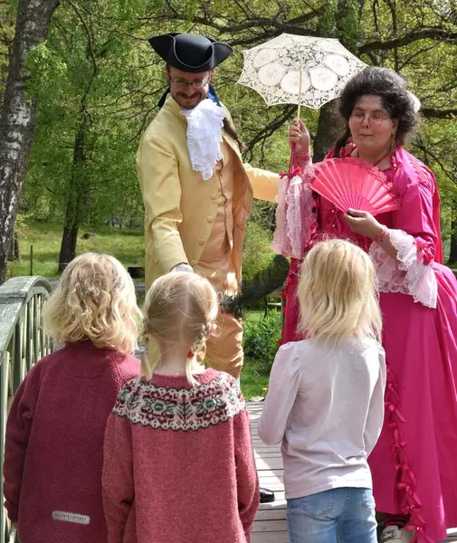 Barn ser på to vosne i historiske kostymen i parken på Bgstad Gård