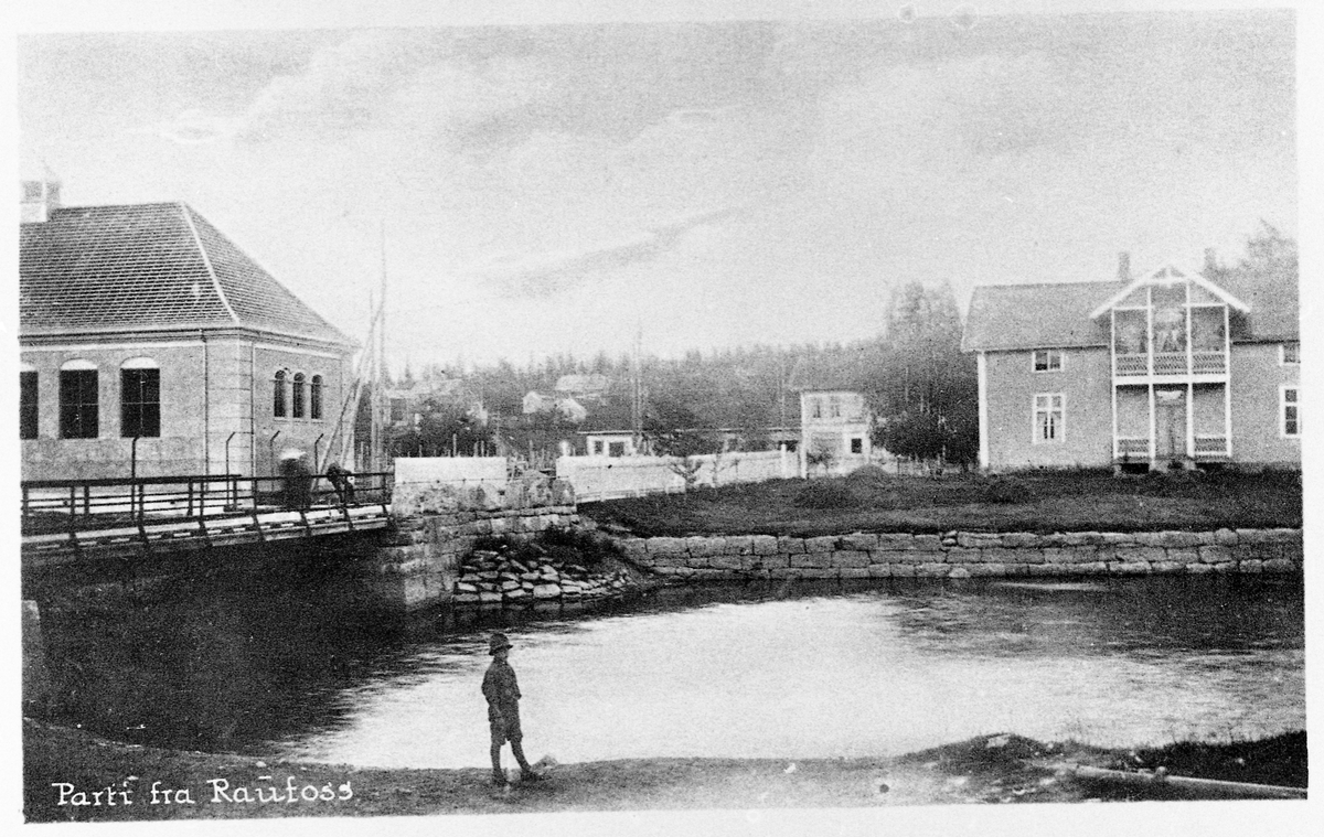 Postkort Raufoss ca. 1918-19. Brubakken med skolebrua og gymsalen. Christensengården i bakgrunnen, og gamle Brubakken skole.