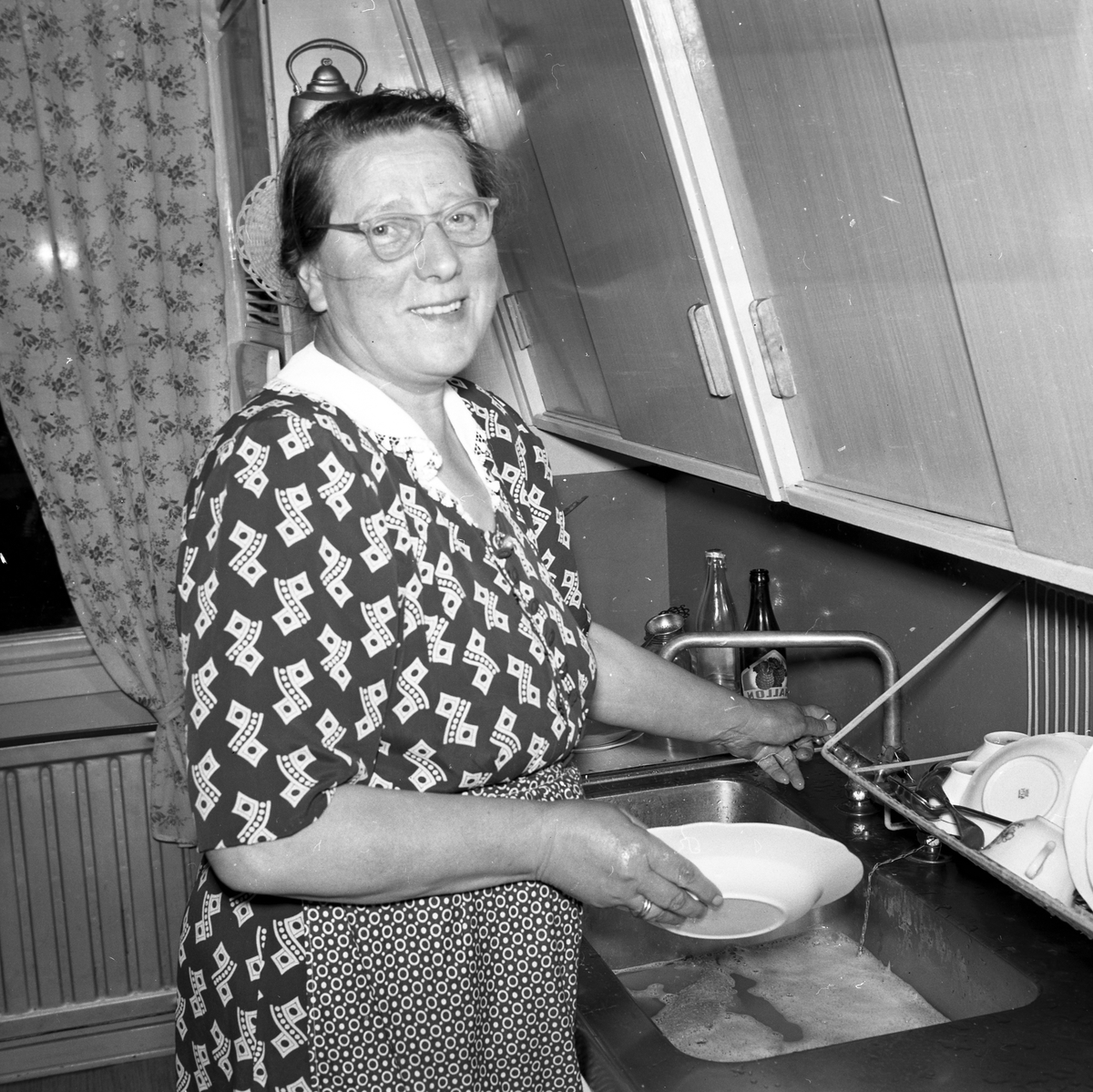 Kvinna diskar i köket.