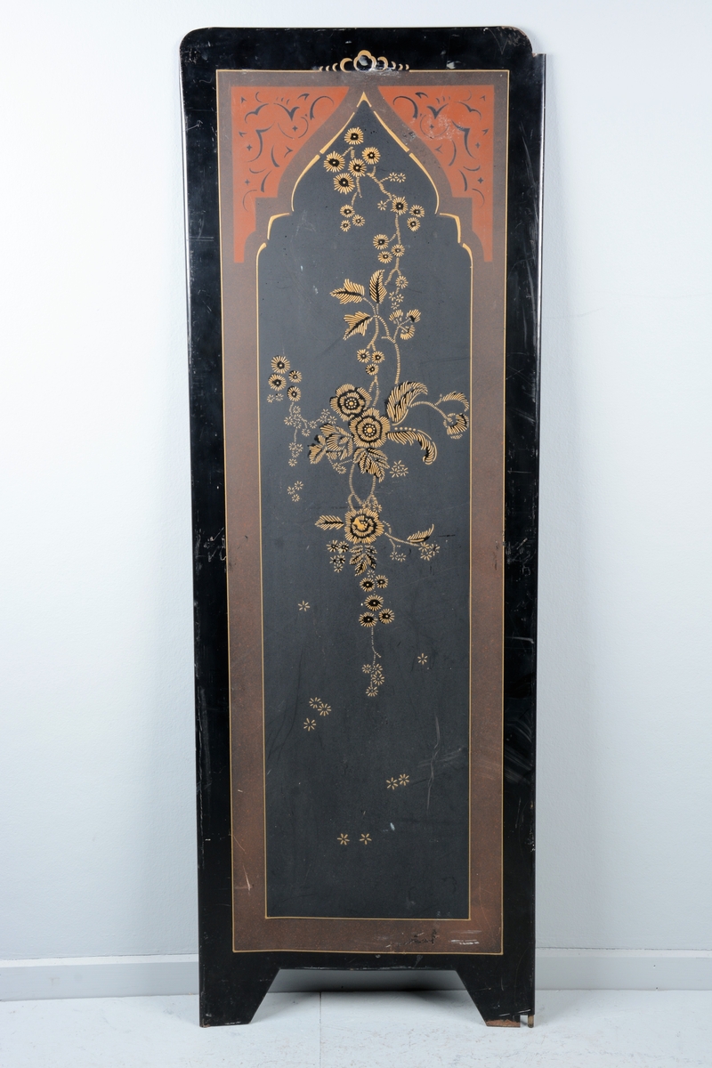 Svart skjermbrett av metall bestående av to paneler. Disse er dekorert med påmalt dekor i form av blomster i en ramme med løkformet overkant og med arabesker.