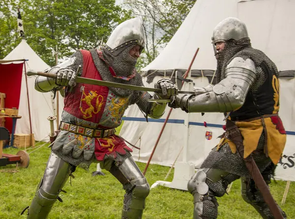 To riddere i platerustning som sloss med lange økser