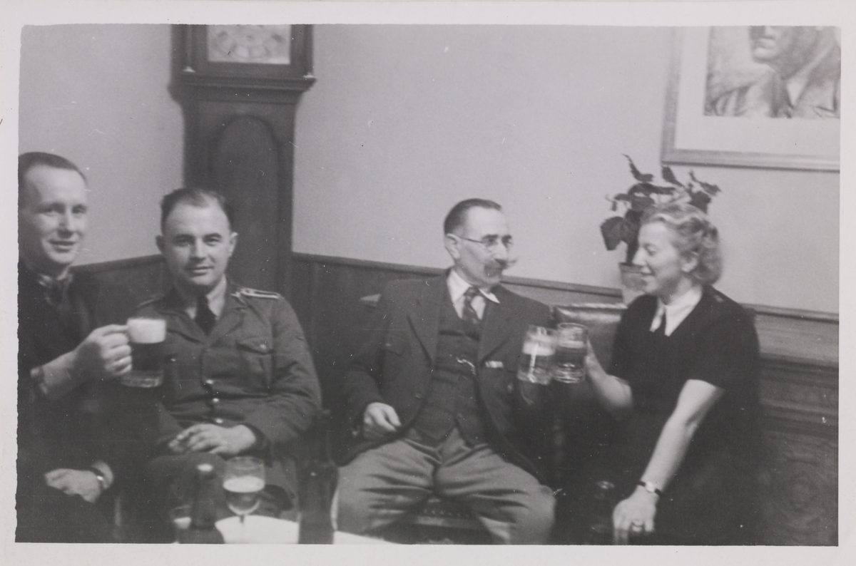 Gruppebilde av tyske fangevoktere som drikker øl. Nummer to fra høyre ser man Zimbowski skåle med ukjent kvinne. Til venstre for Zimbowski sitter Johan Kiel sammen med en annen ukjent tysker.