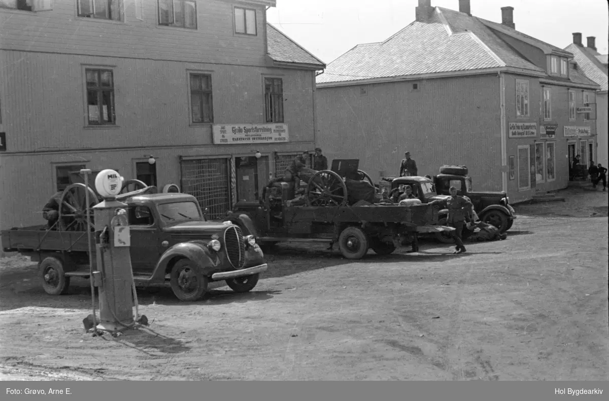 Okkupasjon, kanoner, soldatar, lastebilar (nærmest en Ford V8 1938-39 model): tyskarar, bensinpumpe