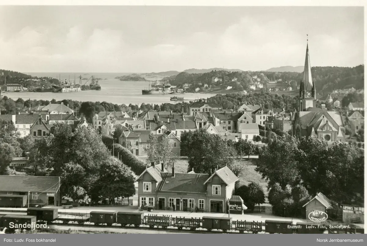 Parti ved Sandefjord stasjon. En rekke godsvogner står på stasjonen ...