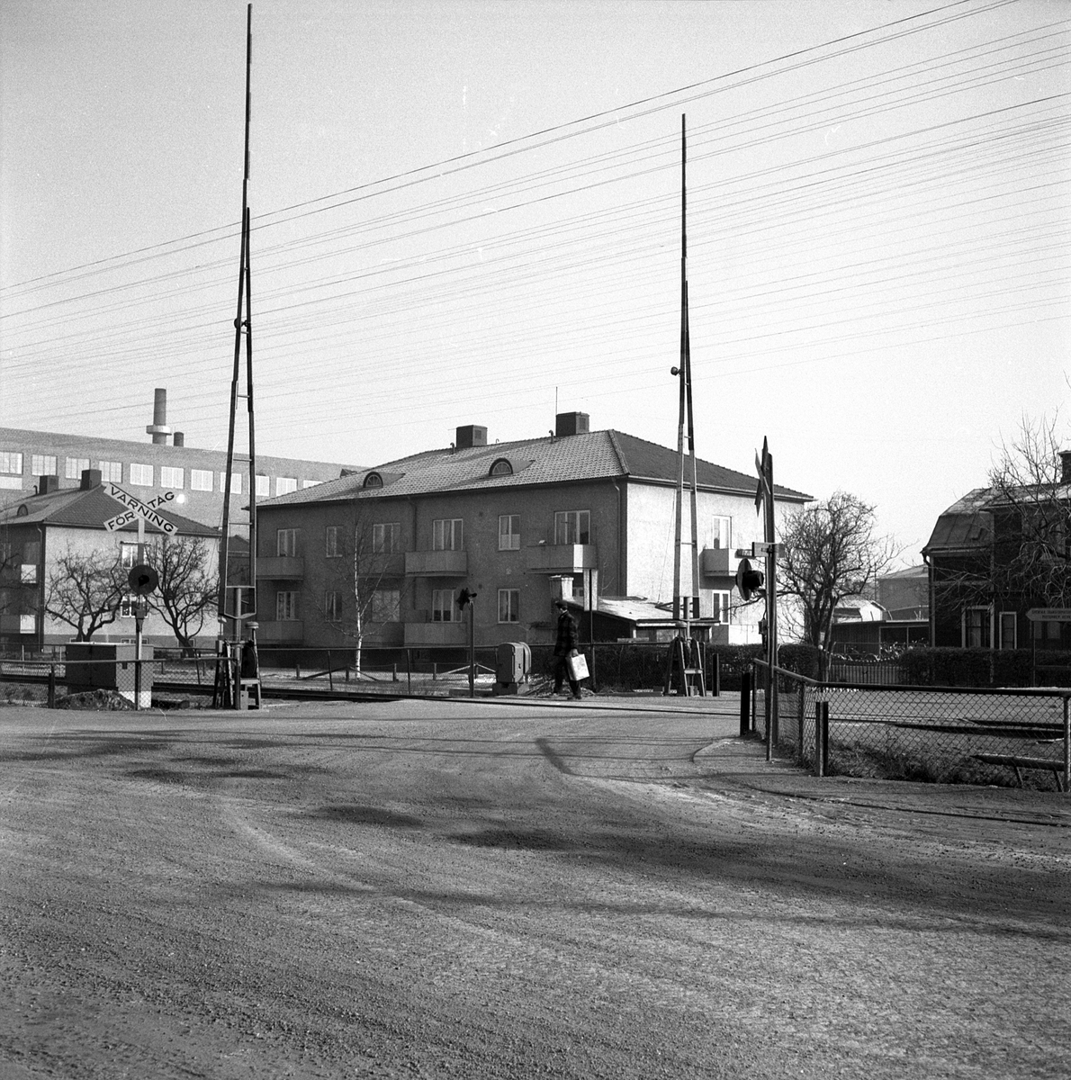 Järnvägsövergången vid korsningen Gamla Tanneforsvägen-Gelbgjutaregatan i Linköping. I blickfånget bebyggelsen i kvarteret Mekanikern. Till vänster skymtar del av Stal-Lavals anläggning.