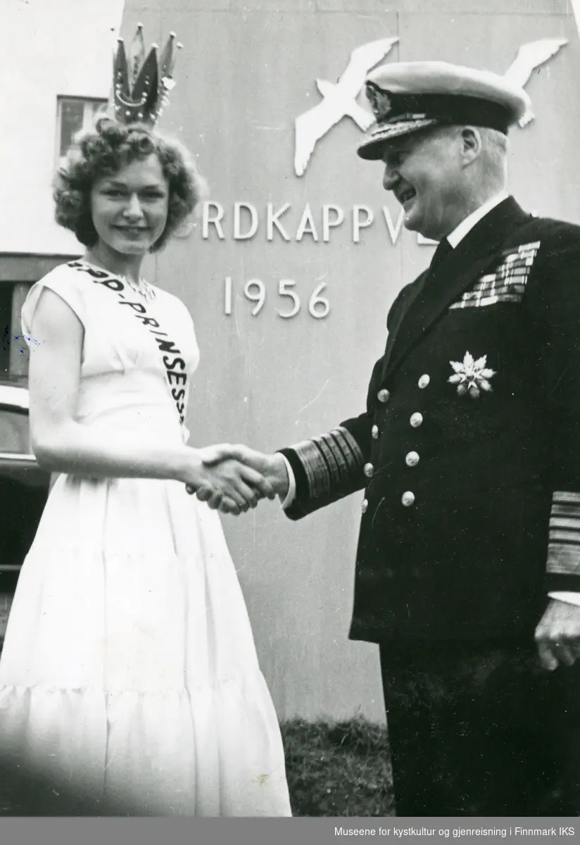 Nordkappfestivalen 1956. Nordkapp-prinsessa Greta Uttakleiv hilser på Lord Fraser of North Cape. I bakgrunnen festivalmonumentet ved posthuset. 29.06.1956.