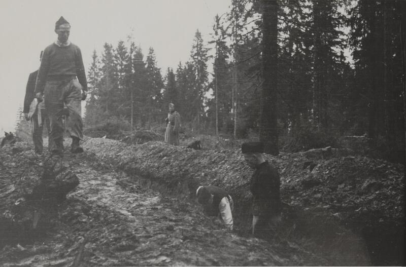 Svart/hvitt fotografi av fanger som arbeider i skogen.