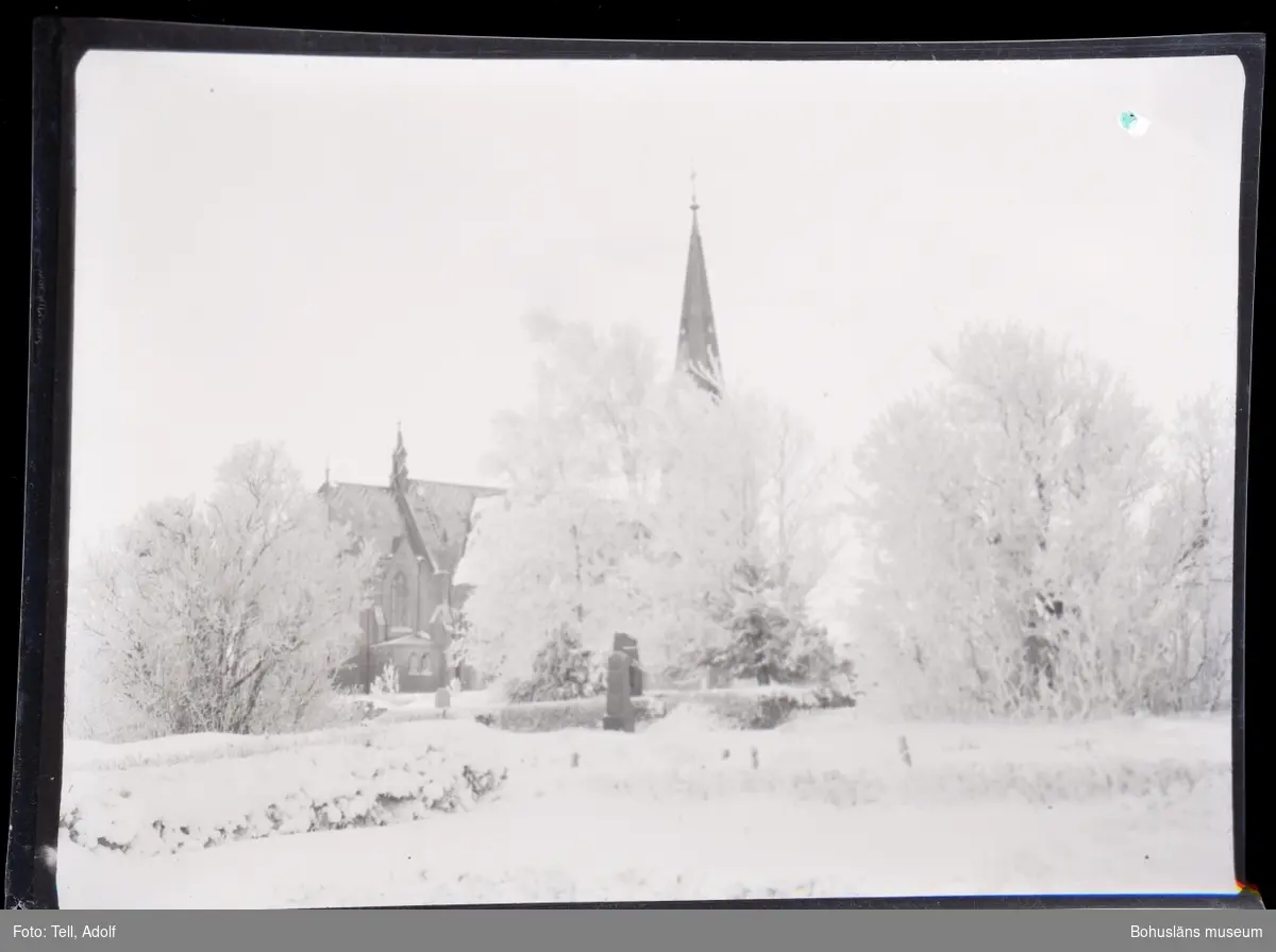 Snötäckt landskap med kyrka i bakgrunden.