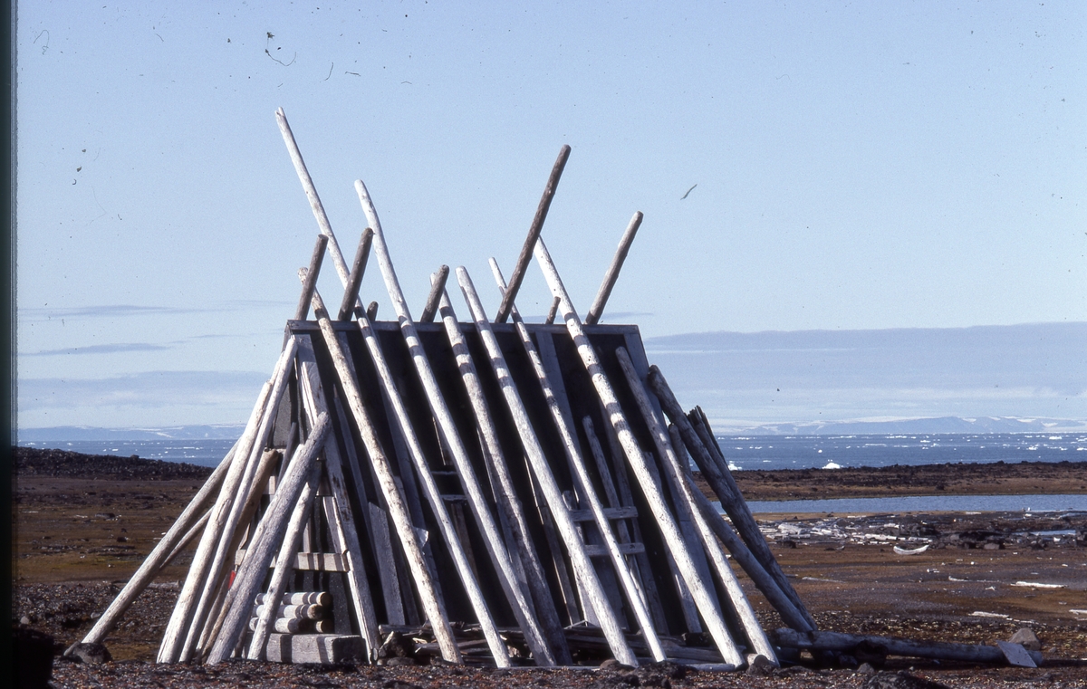 Trekanthytte på Lurøya i Tusenøyane.Hytta ble satt opp i forb med oppmåling. det var en av flere hytter som ble brukt til posisjonerinsarbeid med HI-FIX-systemet. Hytta ble brukt av biologer som jobbet på Tusenøyane. Stokkene er satt opp for å beskytte den mot isbjørn.