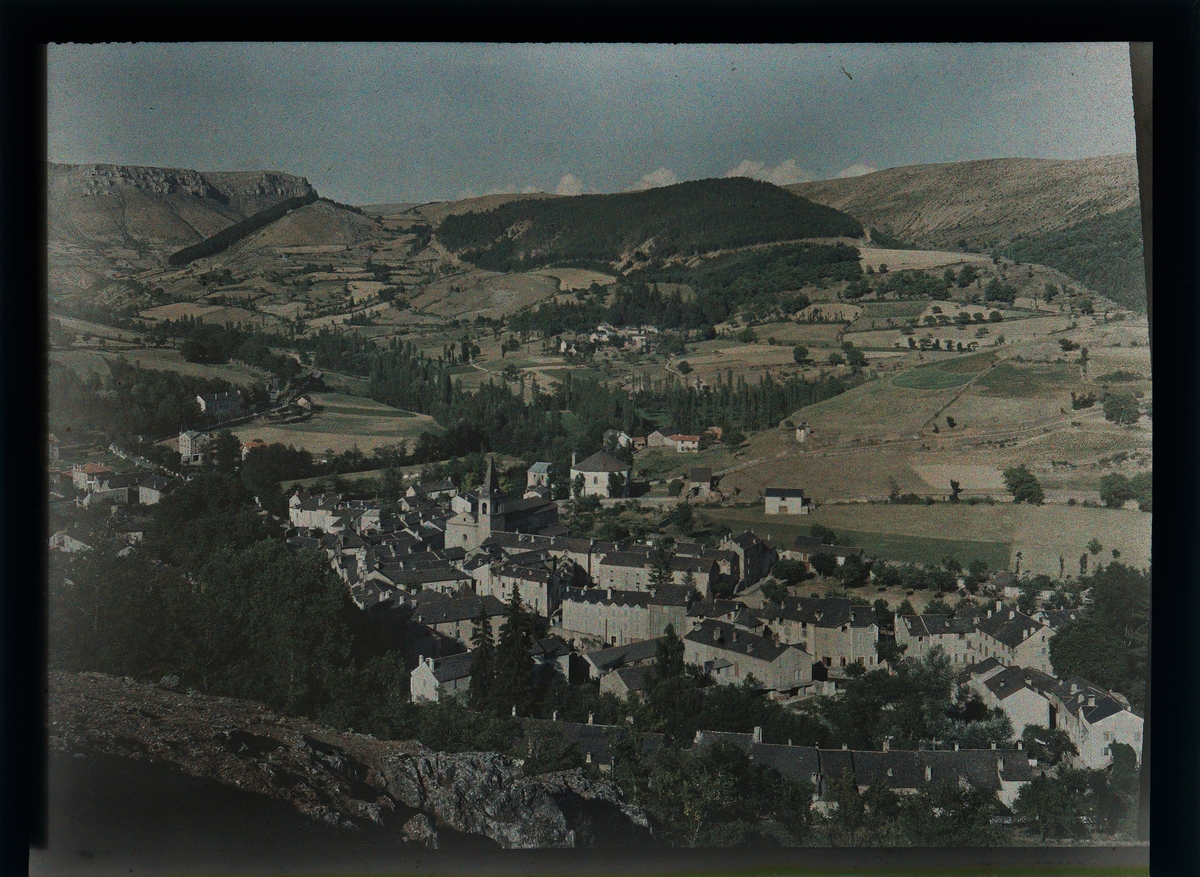 Utsikt over en landsby omgitt av fjell.