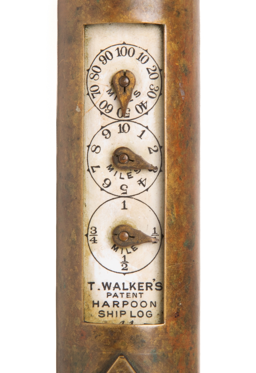 Patentlogg med loggklocka.
Av mässing. T. Walkers Patent, loggen är 50 cm lång, med styre och snedställda vingar. Klockan 16 cm lång.
