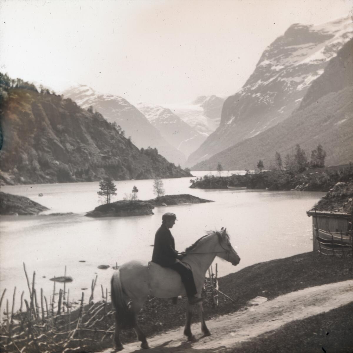 Dias. En mann rir på en fjording ved Lovatnet.