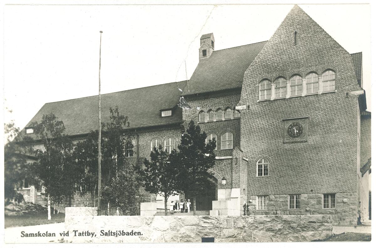 Saltsjöbadens Samskola uppfördes på den av Järnvägs AB Stockholm-Saltsjön skänkta tomten vid Tattby station. Skolan ritades av arkitekt T. Stenberg 1913 och invigdes två år senare. Vykort ca 1930.