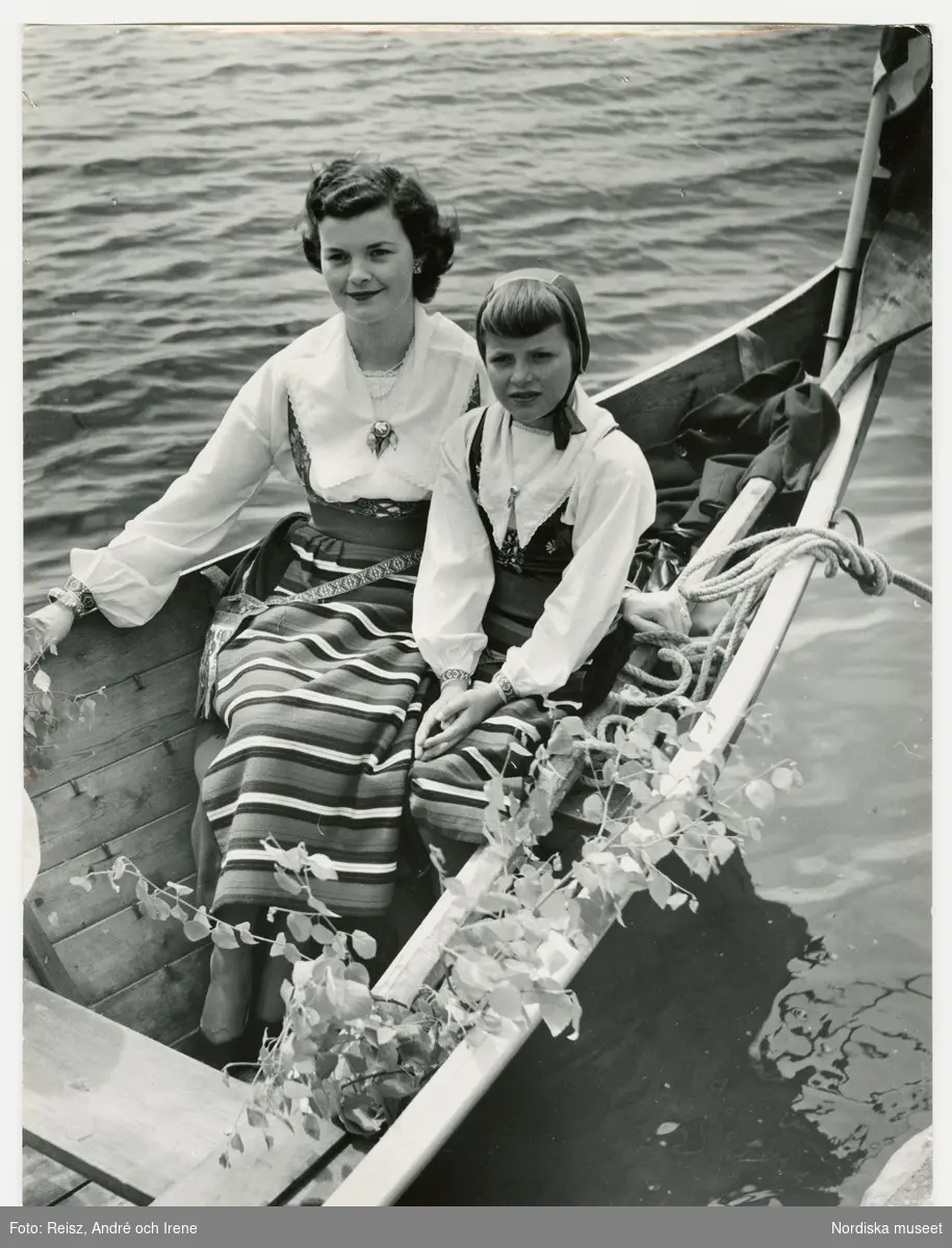 Dalarna. Kvinna med två flickor klädda i Rättviksdräkter i kyrkbåt på Siljan.