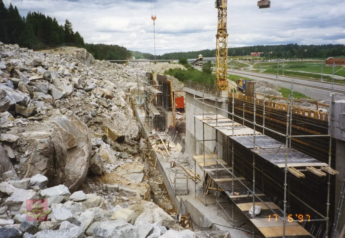 Bygging av Grimsrud bru, E6 syd Follo 17. juni 1997.  Bildet viser syd for Sonsveien stasjon. Jernbaneskinner (NSB) til høyre. Ny jernbane ble tatt i bruk i 1994 og ny E6 i 1998.
Bilder fra Region øst  Romerike distrikt  Akershus.