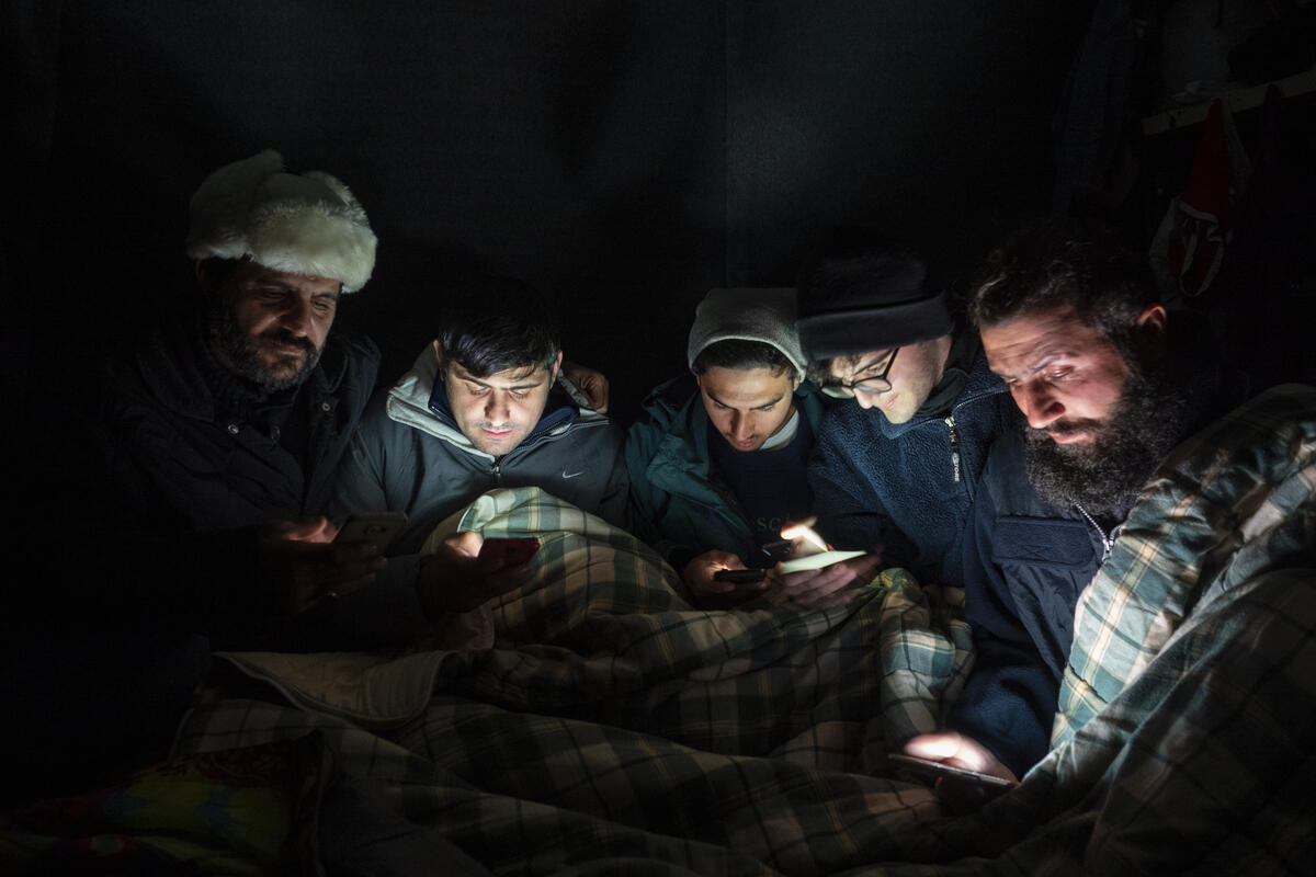 Bilde av en gruppe personer i Moria flyktningeleir. Bildet er tatt på kvelden.