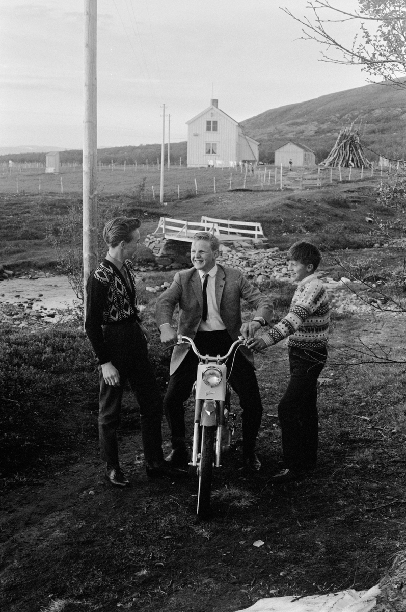 Pent kledde ungdommer med moped i kystlandskap.