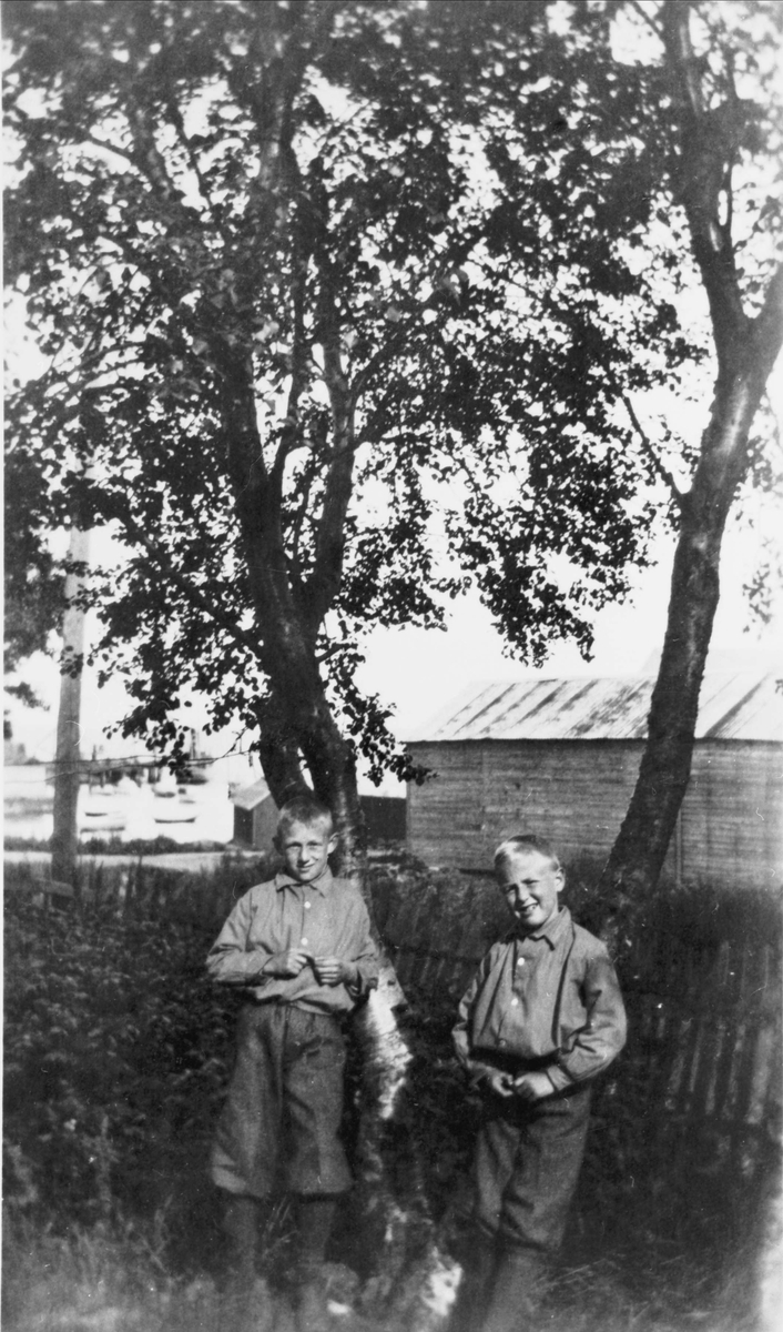 To gutter stående i en hage.