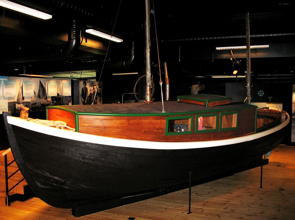 Båt brukt av båtreisende romanifolk/tatere, langs kysten av Norge. Overbygd "oppholdsrom". Utstyr til metallarbeid (takrenner) påmontert utvendig. Inngår i utstillingen "Latjo drom".