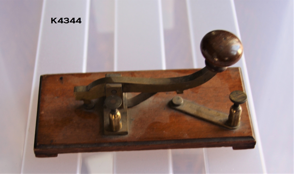 Telegrafnøkkel:
Morsenøkkel montert på tresokkel (eik) som er lakkert.
Knott på nøkkel av tre.