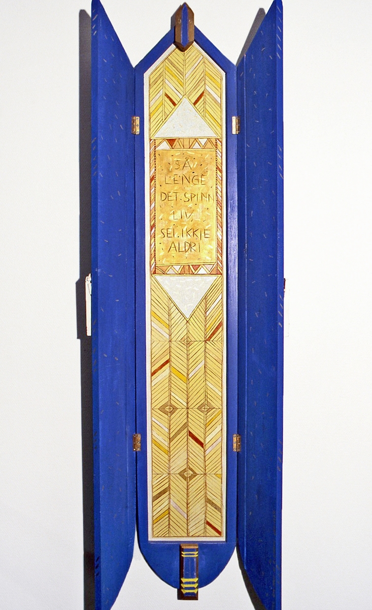 Den koboltblå veggtavlen med dører som åpnes, og innenfor vises en ny tavle i gull med en tekst risset inn:  «Så lenge det spinn liv, sei ikkje aldri». Verket er del av en utsmykking som omfatter 3 arbeider.