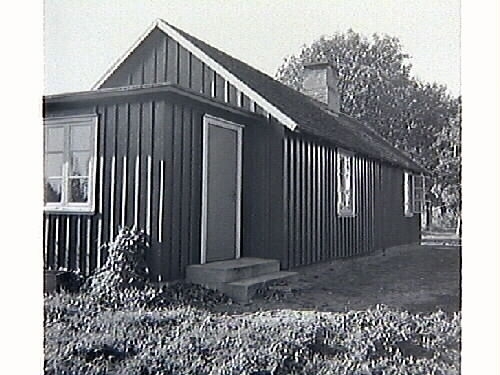 Barnbespisningen till skolan i Spannarp 1949 med byggnaden samt ätande elever och personal.