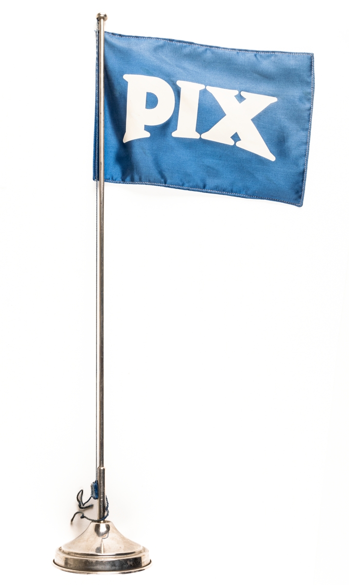 Bordsstandar i metall, blå och vit flagga med text: PIX.