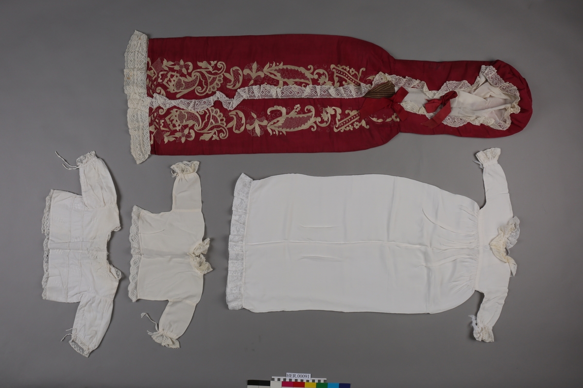 Dåpspose i burgunder silkerips med hvite blonder langs kantene og kremhvit silkebroderi.