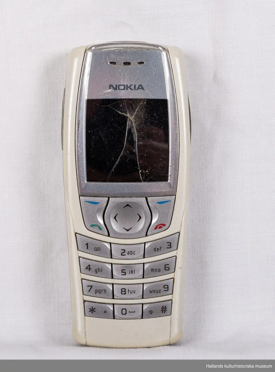Nokia 6610 (Tillverkare: Nokia, modell: 6610) med yttre skal av grå hårdplast. På dess framsida en digital skärn, knappsats i silverfärgad hårdplast, samt tillverkarens logotyp "Nokia" ovanför skärmen. Telefonens baksida (även den märkt med företagets logotyp) är avtagbar för åtkomst till batteri och telefonkort (simkort). I telefonen sitter ett telefonkort från teleoperatören Telia. På telefonens undersida en kontakt under lucka.

Skärmen har en krosskada.