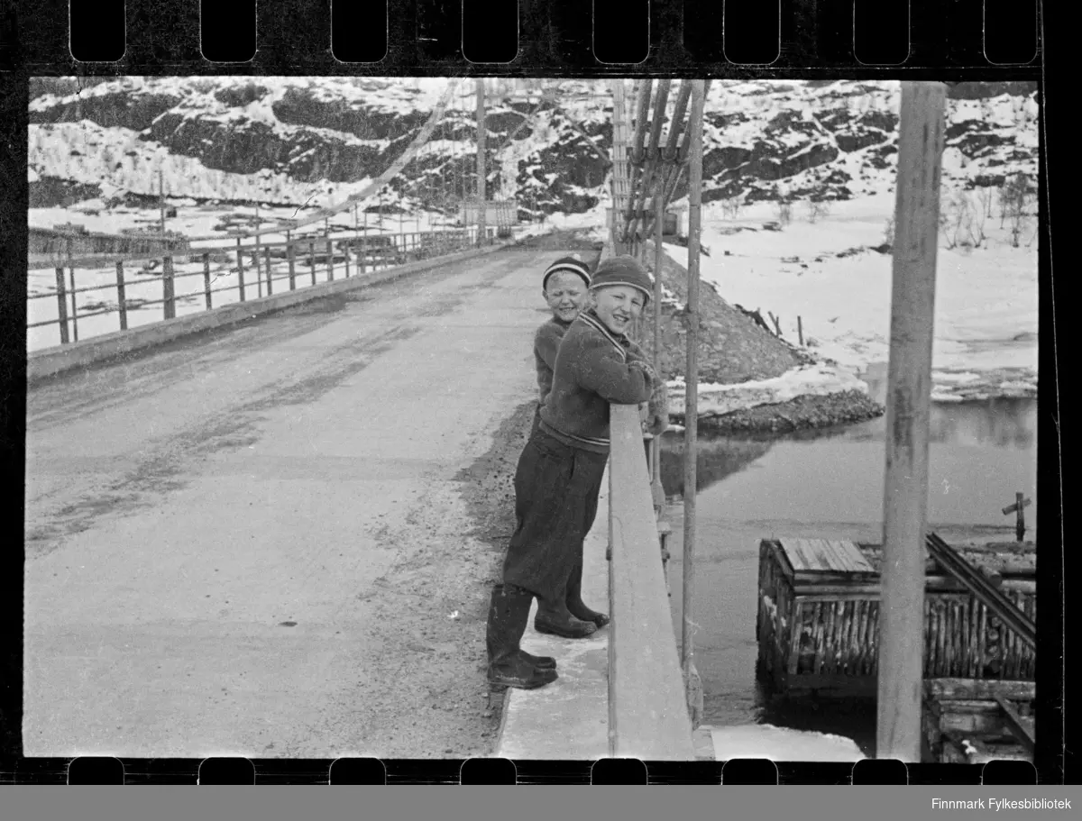 Foto av to gutter på Elvenes bru i Sør-Varanger.

Foto antagelig tatt på slutten av 1940-tallet, tidlig 1950-tallet 