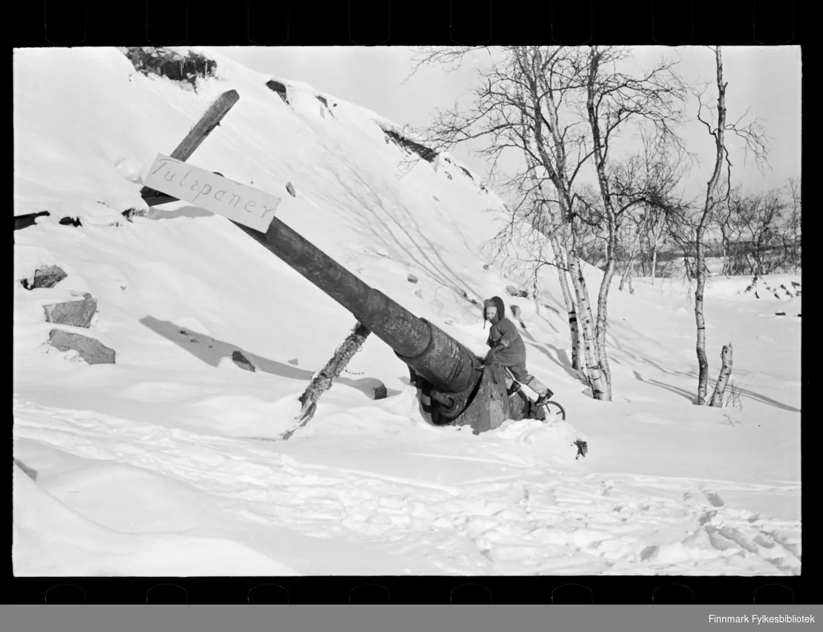 Foto av nedsnedd maskineri med skilt på. Ruiner av kanon?  På skiltet står det "Tulipaner"  og en liten gutt står ved siden av. 

Muligens tatt i 1947 (se historikk)

Foto trolig tatt på slutten av 1940-tallet, eller tidlig 1950-tallet