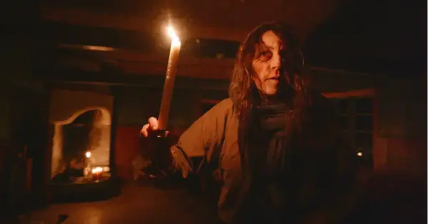 En skummel dame står i mørket og holder et stearinslys, under arrangementet Natt på museene på Anno Glomdalsmuseet.