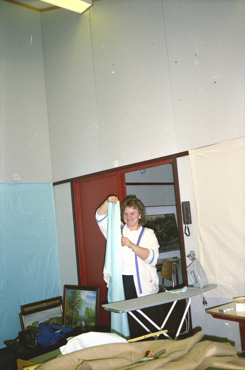 Kronprinsparet besøker Hitra 1989 : Forberedelser, Tove Nordin Skipnes klipper til stoffet som skal henges på veggen.