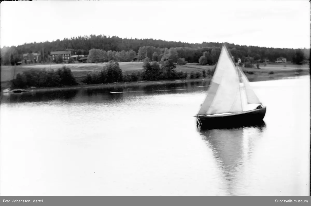 Gustaf Perssons segelbåt ute på sjön Marmen. Bakom syns Lucksta med bland annat gamla baptistkapellet till vänster.