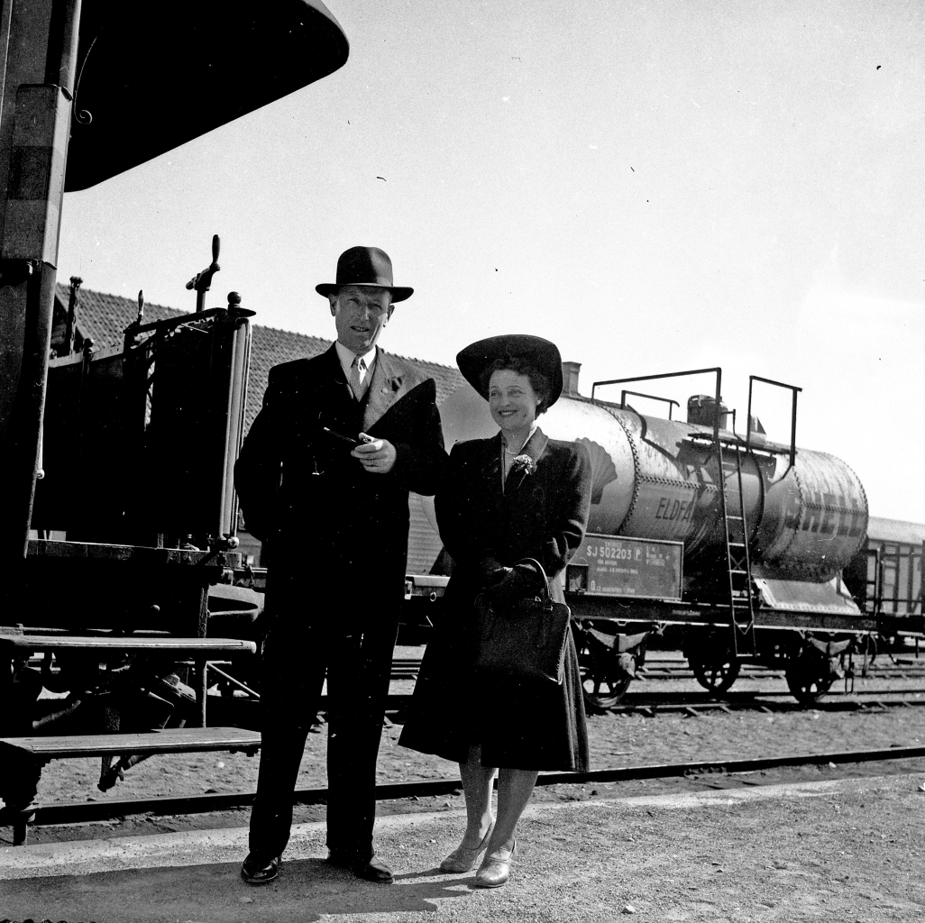 En man och en kvinna ståendes vid ett tåg.