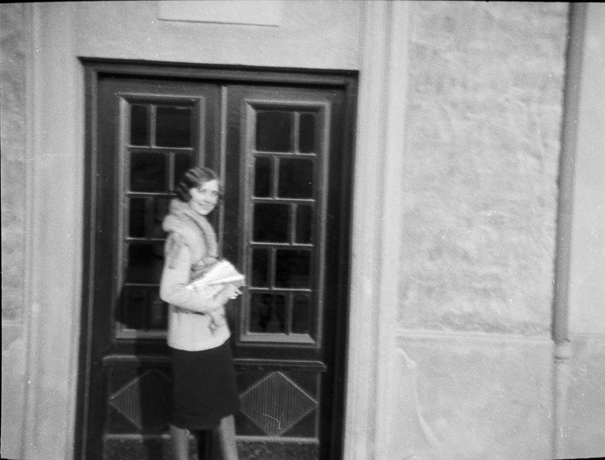 En kvinna står vid en ytterdörr, Uppsala