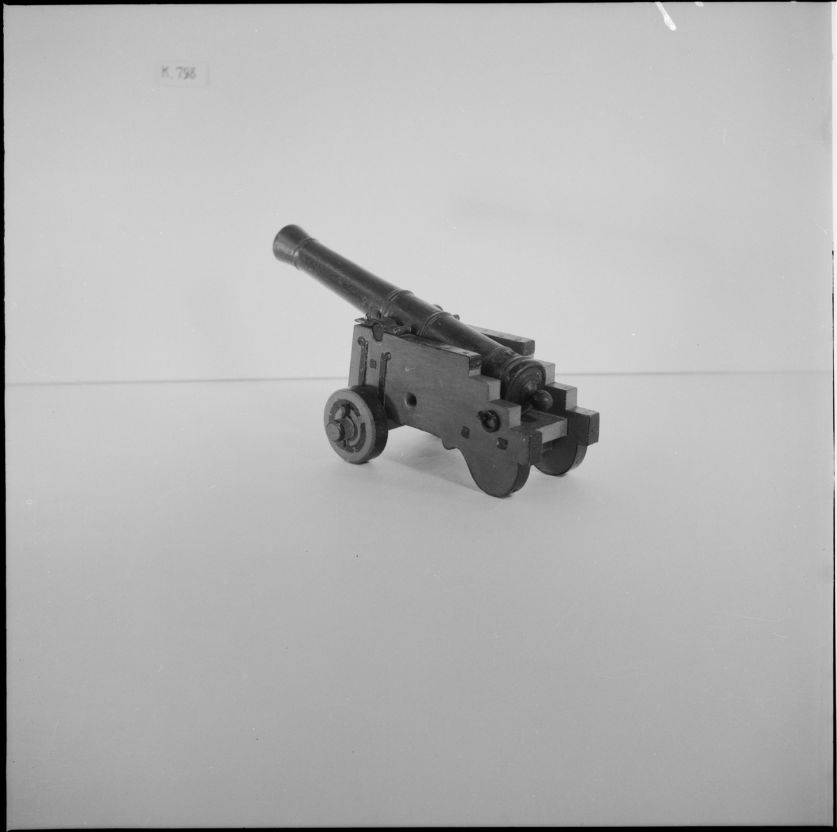 Kanonmodell: skans- eller släplåda, med kanon av Tornqvist. Modellen antagen 1757. Lavetten av trä med beslag av järn. Kanonen av trä. Lådan röd, kanon och beslag svartmålade. Tillbehör: 1 st riktkil. Lavetten L = 190 mm B = 140 mm H = 120 mm.