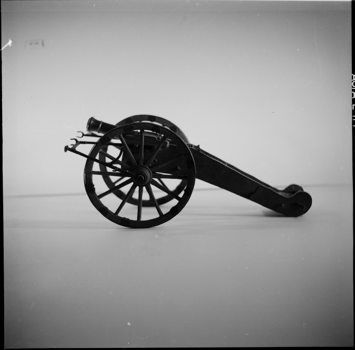 Kanonmodell: Modell av Artillerifältkanon med landlavett och 2 hjul. Modellen av trä, med beslagen av järn. Lavetten L = 460 mm B = 330 mm H = 190 mm.