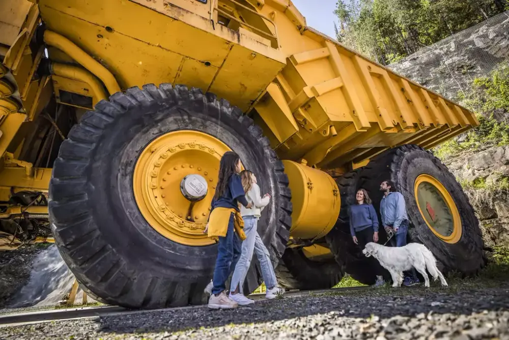 Bildet viser besøkende som står ved en stor dumper.