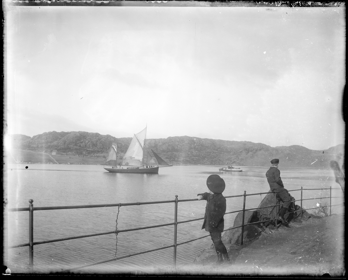 En gutt og en mann i Varbergveien ser utover Søra Sundet ved Egersund med båter