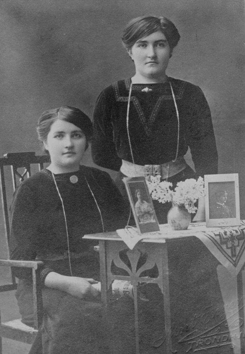 Studioportrett av søstrene Borghild Konstanse Kongsnes (står) og Elise Nikoline Kongsnes