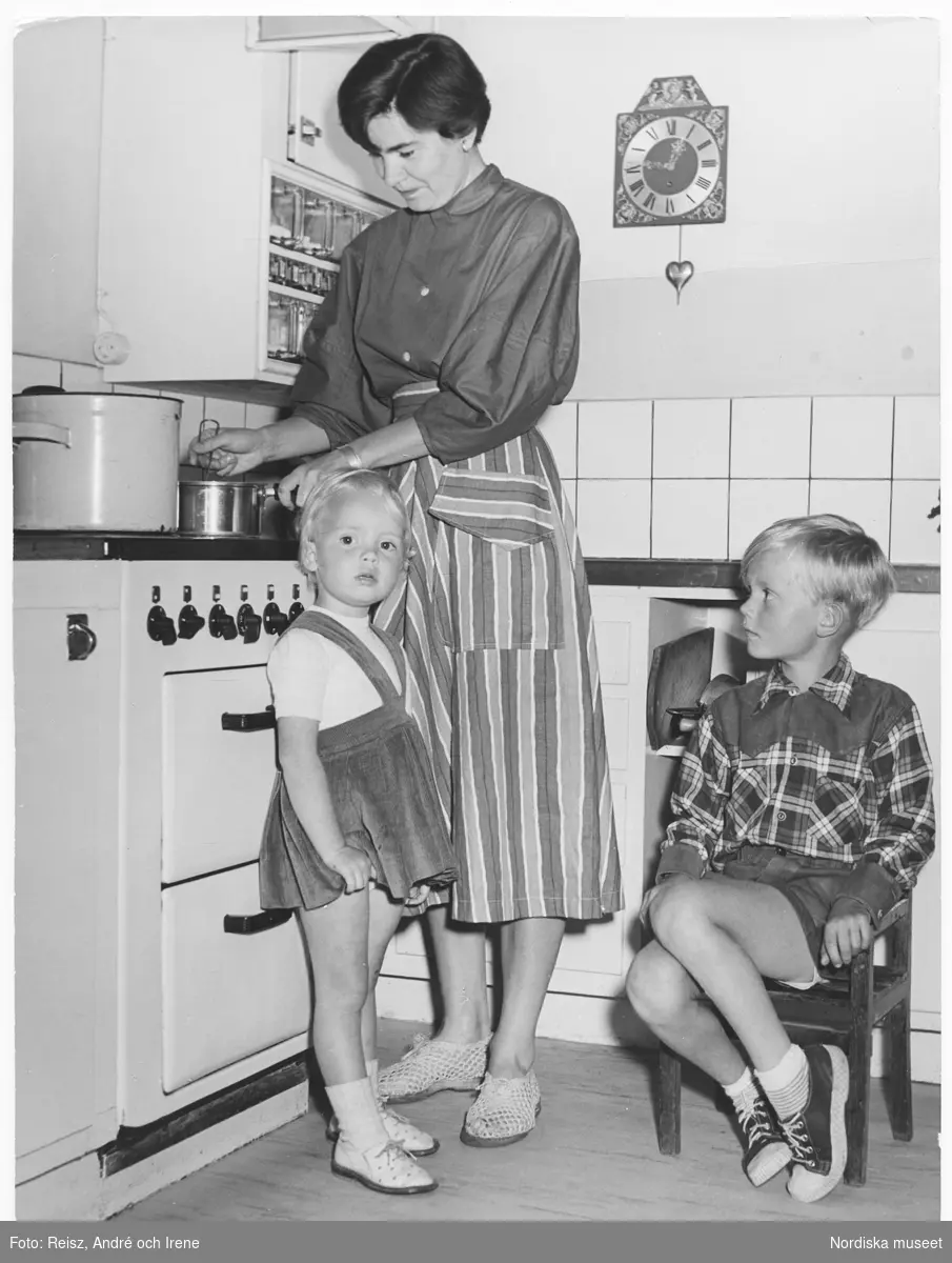 Teddi Orup, konstnären Bengt Orups fru med deras två barn vid elspisen i köket i deras moderna lägenheten.